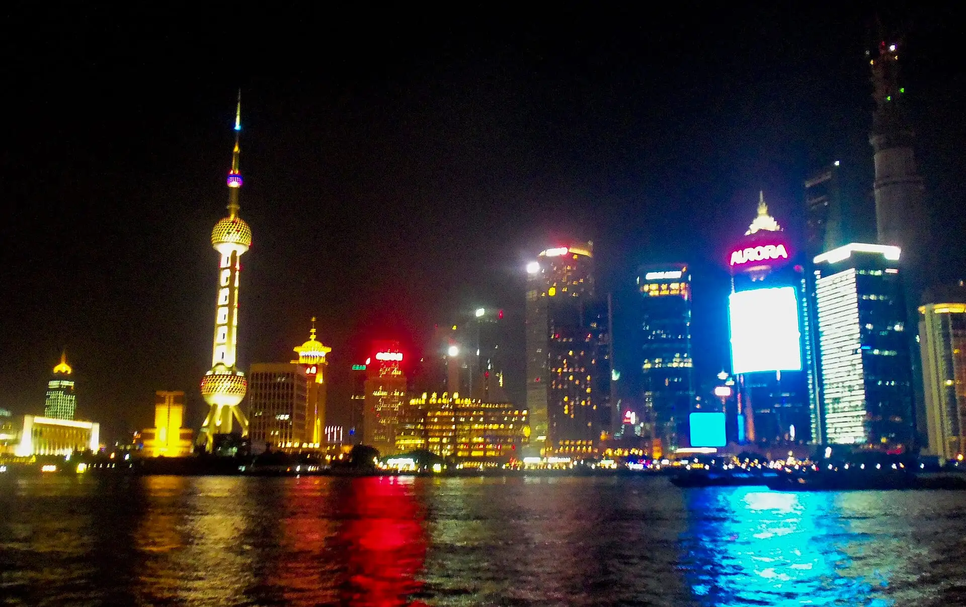 Shanghai's Lujiazui skyline at night from the Bund across the Huangpu River, with all of its buildings fully lit.